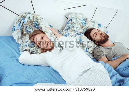 young caucasian couple in bed. male snoring and female can not sleep