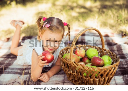 little girl with apples in park