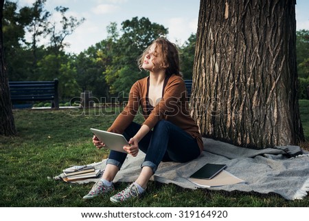 young caucasian female student with tablet on campus, student study in campus area using tablet