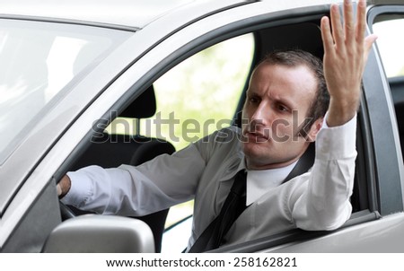 Stressed and angry businessman in a car, during the rush hour.