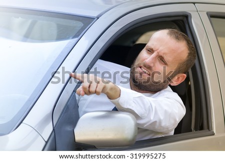 Businessman stuck in the traffic gesturing angry