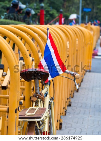 Bangkok, Thailand - 29 NOV 13: A bicycle with Thai flag in front of the policemen\'s defend at Ministry of Defence.