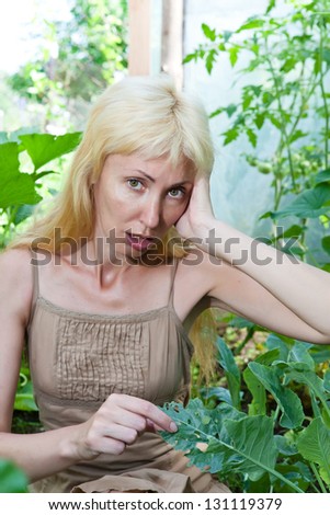 The young attractive woman is upset - caterpillars eat leaves of plants