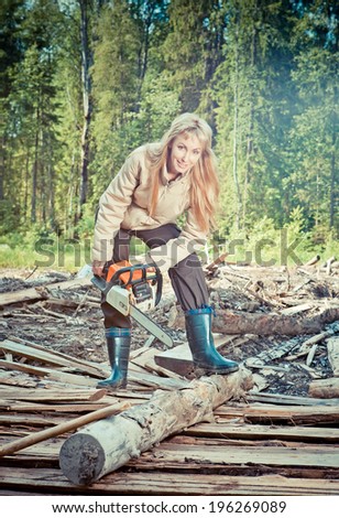 The young woman in wood saws a tree a chain saw,with a retro effect