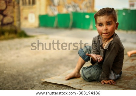 alone sad child playing on a street