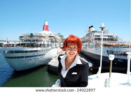 Attractive crew member on the top deck of a cruise ship going through the port