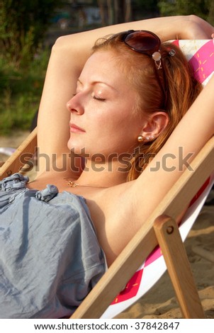 Beautiful woman lying in the chair during sunset