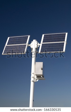 Two solar panels for green electricity mounted on a white post