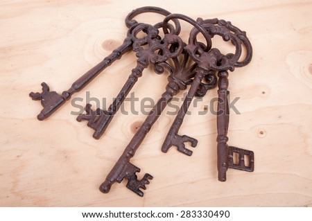 Five antique rusty keys on a wooden background