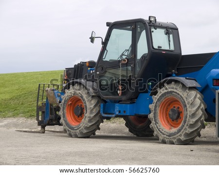 Tractor with pallet fork standing on road