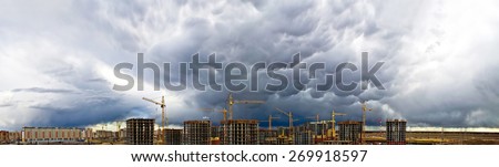 Construction crane industrial concrete skyscraper storm rain weather sky panorama