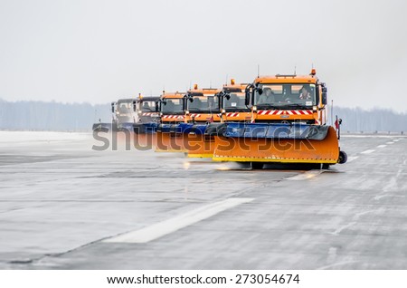 Snow machines on the asphalt runway rain snow removal. Russia, Tyumen city, Airport Roschino 13 March 2014