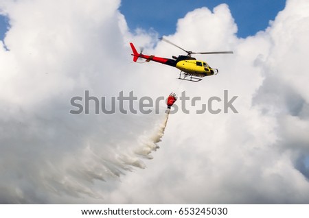 Similar – Image, Stock Photo A firefighting helicopter pours water into a forest to put out a forest fire