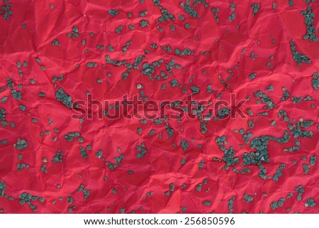 background wrinkled sheet of paper color red is sprinkle with a little gravel.