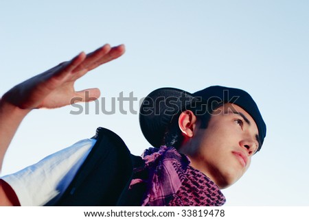 A hip hop guy standing with his hand out as if to slap someone five