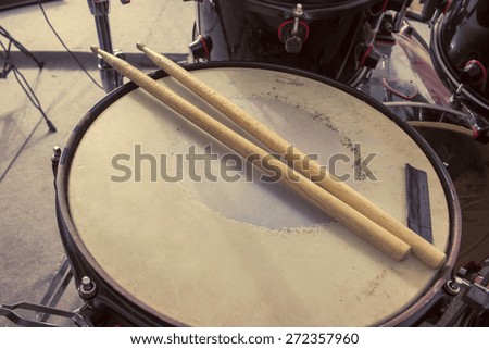 Picture of drums and drumsticks lying on snare drum.Retro vintage picture