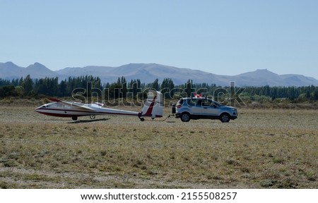 glider towed by a car on the runway and then take off towed, white and red ultralight glider 商業照片 © 