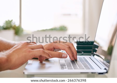Close-up of hands busy working on a laptop, with copy space