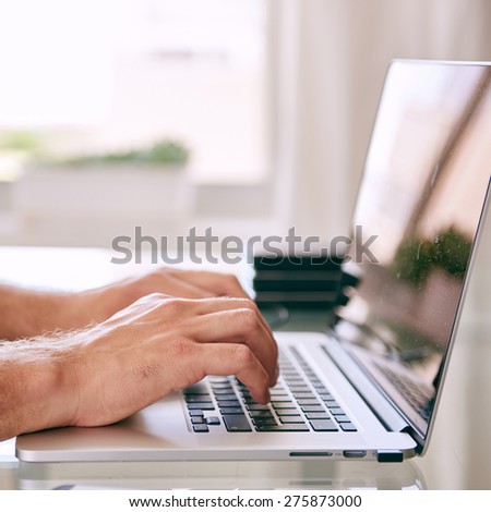 square close up image of hands busy working on a modern laptop computer with copy space