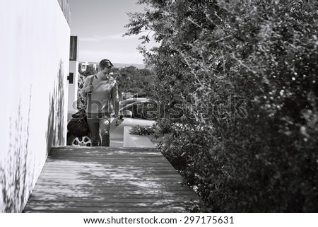 Black and white image of a young professional business broker arriving home