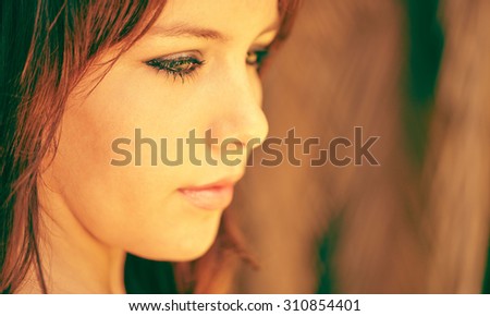 Young caucasian teenage girl looking slightly depressed as she looks down to the ground with beautiful copy space to the right