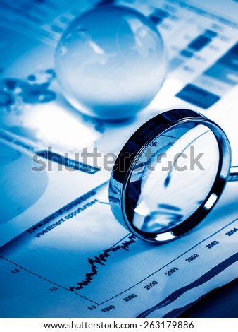 Business Data Analyzing, with magnifying glass and other on the desk.