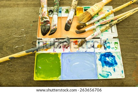 Artist palette with various colors on wood background