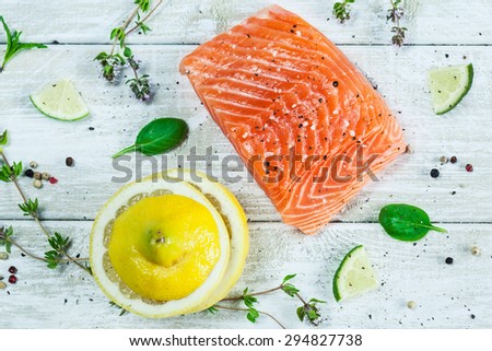 Fresh raw salmon fillet on wooden rustic table - top view. Healthy food, diet or cooking concept.