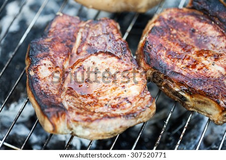 Top sirloin steak on a barbecue, shallow depth of field. Summer BBQ closeup, outdoor grill concept. Grilled steak meat cooked on carocal.