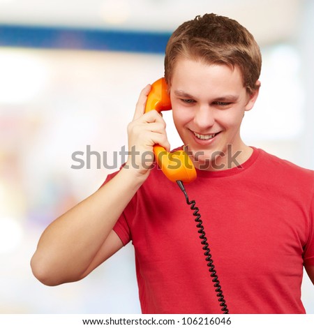 portrait of a young man talking on a vintage telephone indoor