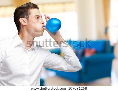 Portrait Of Young Man Blowing Balloon, Indoor