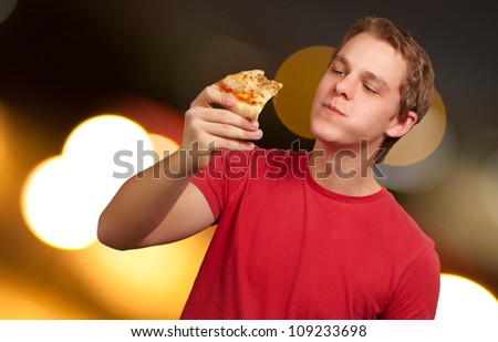 portrait of a young man eating pizza, background