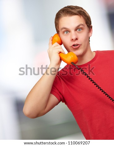 Portrait of a young man talking on vintage phone, indoor