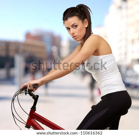 portrait of young woman cycling at city