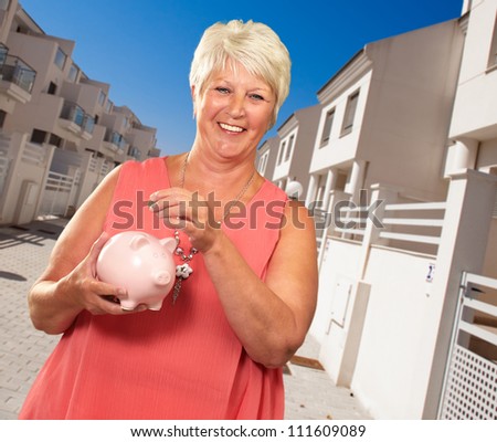 Senior Woman Holding A Piggy bank, Indoor