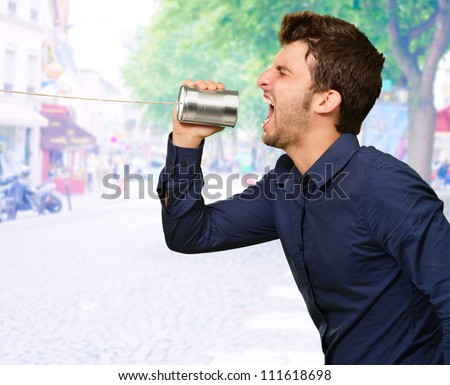 Man Shouting In Tin Can Telephone, Outdoor