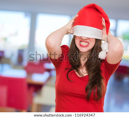 angry woman with a christmas hat covering her eyes, indoor