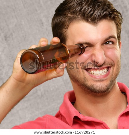 man looking inside an empty bottle, indoor