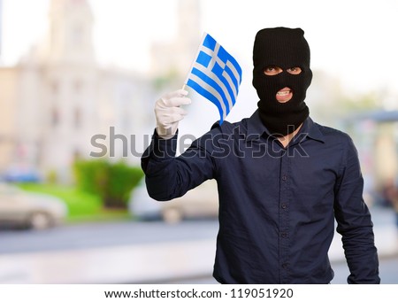 Portrait of a man wearing mask holding a flag, outdoor