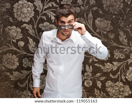 Portrait Of Young Man Giving Look While Holding Glasses On Flora Wallpaper