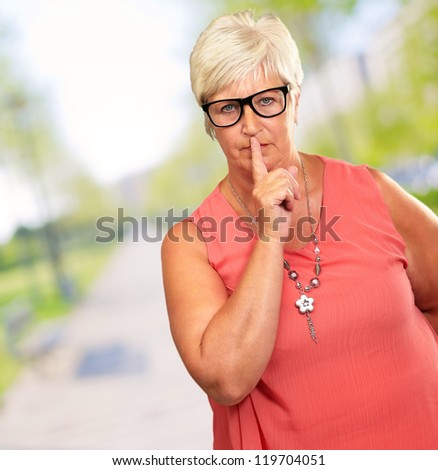 Senior Woman With Finger On Lips, Outdoor