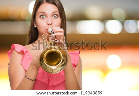 Young Woman Blowing Trumpet against a city by night