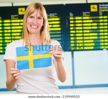 Happy Woman Holding Swedish Flag at the airport