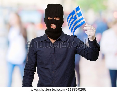 Portrait of a man wearing mask holding a flag, outdoor