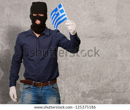Portrait of a man wearing mask holding a flag, indoor