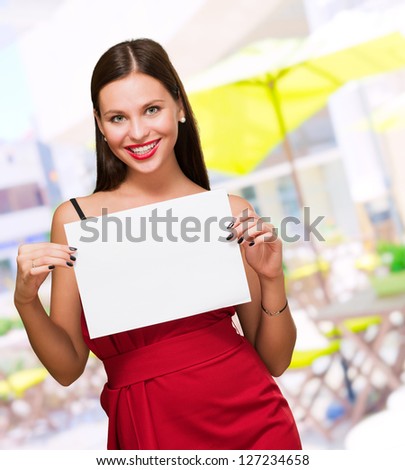Beautiful woman holding a blank placard at a restaurant