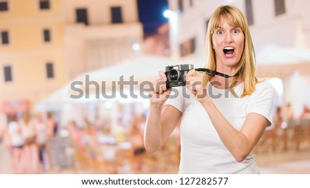 Shocked Woman With Old Camera at a city by night