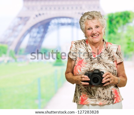 Happy Mature Woman Holding Camera, Outdoors