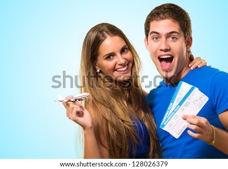 Couple Holding Boarding Pass against a blue background