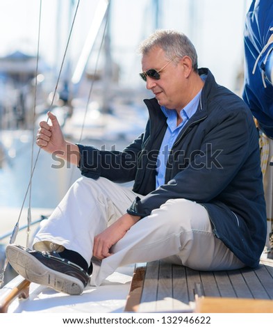 Mature Man Sitting On Sailboat, Outdoors